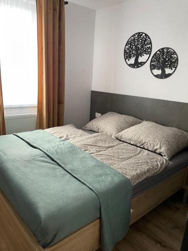 a bed in a bedroom with two trees on the wall at Rado Apartments in Jezersko