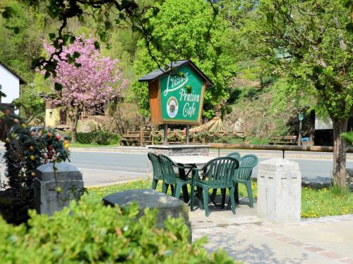 a table and chairs in a park with a sign at Café Pension Leistner in Obertrubach