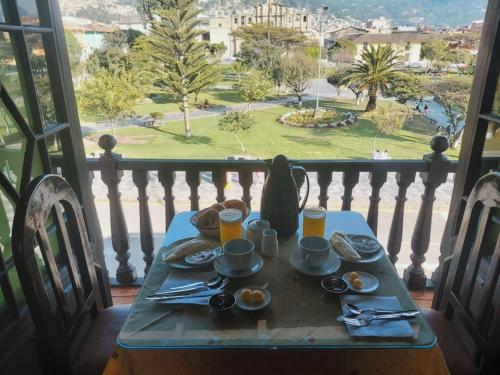a table with breakfast food on a balcony with a view at Casona del Inca Cajamarca in Cajamarca