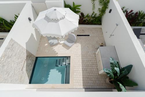 a house with a swimming pool and an umbrella at Stylish West Coast 3BR Retreat with Pool Near Beach in Saint James