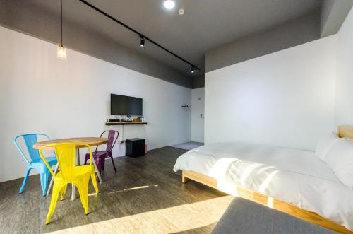 Un dormitorio con una cama y una mesa y sillas. en Sea breeze Inn, en Jian