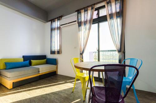 Una sala de estar con una mesa y sillas y un sofá. en Sea breeze Inn, en Jian