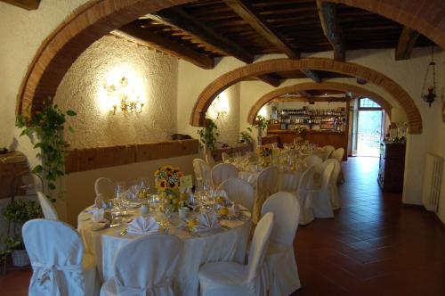a banquet hall with white tables and white chairs at Hotel Belvedere Di San Leonino in Castellina in Chianti