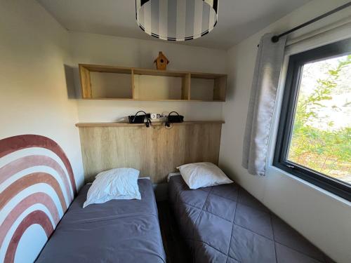 a small room with two beds and a window at La Cabane du Lac - Biscarrosse 5 étoiles in Biscarrosse
