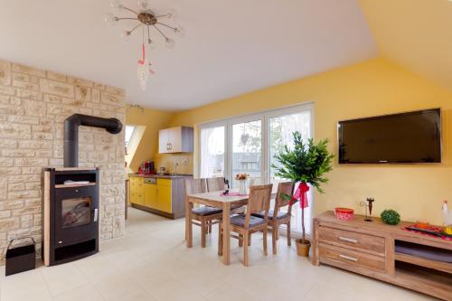 a living room with a table and a tv on the wall at Matys Landhausperle an der Müritz in Röbel