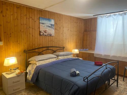 a bedroom with a bed with a blue blanket at Logudoro Cabin by Holiday World in Alghero