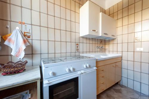 a kitchen with a white stove and a sink at Casa Lucia a Torre Lapillo in Torre Lapillo
