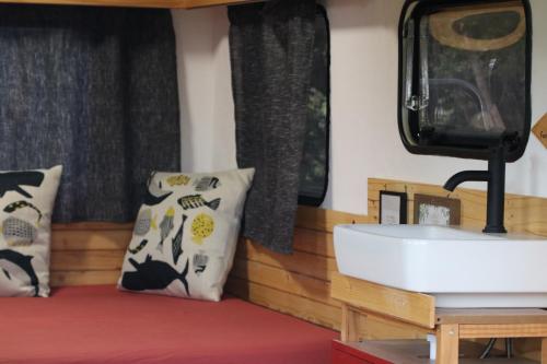 a room with a sink and pillows on a bed at La caravane plage in Pietroso
