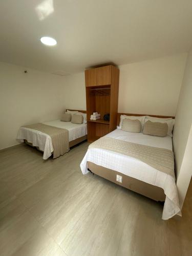 a bedroom with two beds in a room at Casa da Dinda 107 in Rio das Ostras