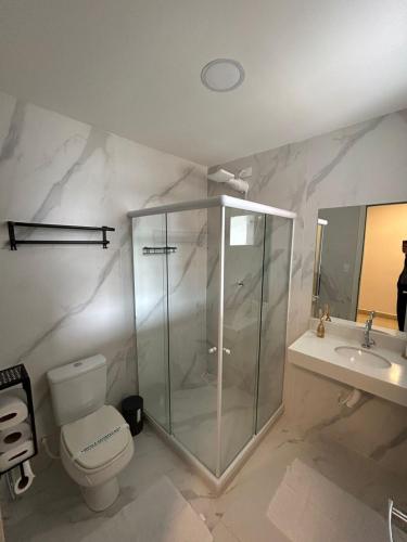 a bathroom with a shower and a toilet and a sink at Casa da Dinda 107 in Rio das Ostras