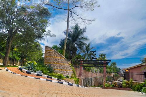 a surfboard is sitting next to a brick road at Acacia Green Service Apartments in Kampala
