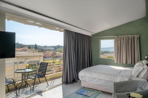 a bedroom with a bed and a balcony with a tv at 24K Athena Suites in Athens
