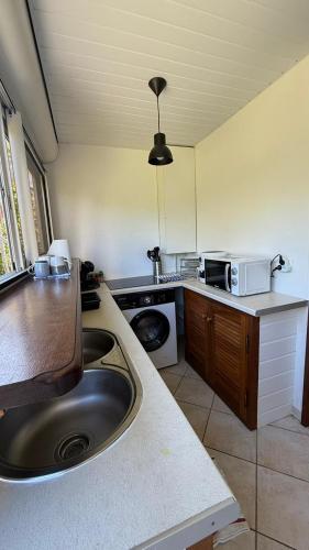 a kitchen with a sink and a counter top at Peace's House, Studio moderne, Bas-du-Fort, Plage à pied, Parking privé in Le Gosier