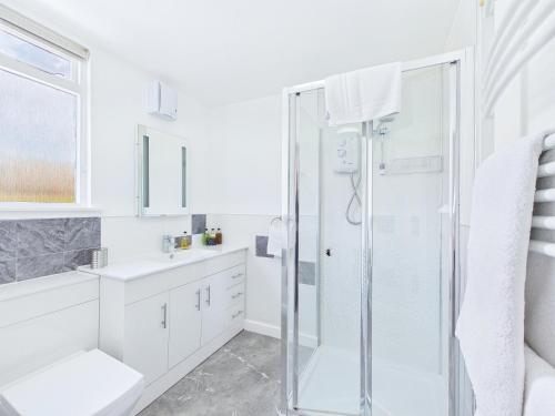 a white bathroom with a shower and a sink at Dunroamin Bed and Breakfast in Aviemore