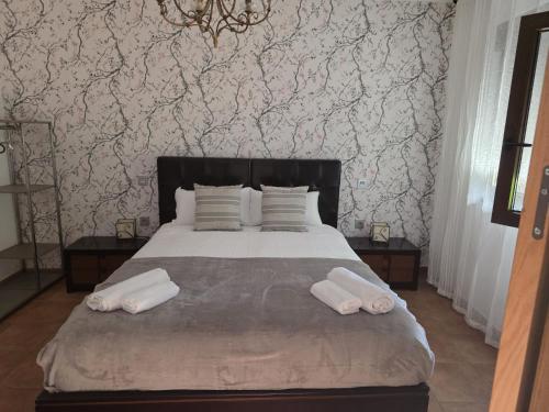 a bedroom with a bed with two towels on it at White Tree JARA - Casa Rural para grupos con piscina en Zamora in Rabanales
