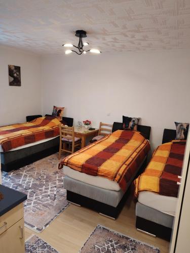 a room with two beds and a table in it at Apartmani Konta in Livno