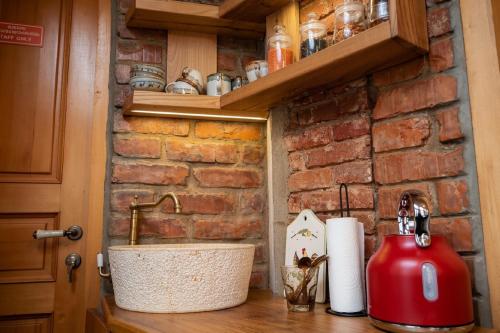 a kitchen counter with a sink and a brick wall at Hotel Commune 1889 in Kutaisi