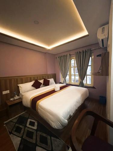a bedroom with a large bed and a window at CG Hotel in Kathmandu