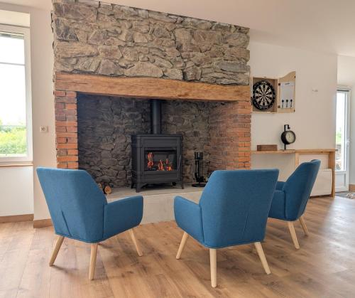 a living room with two chairs and a fireplace at Ferme Équestre Equi'Cantal in Montboudif
