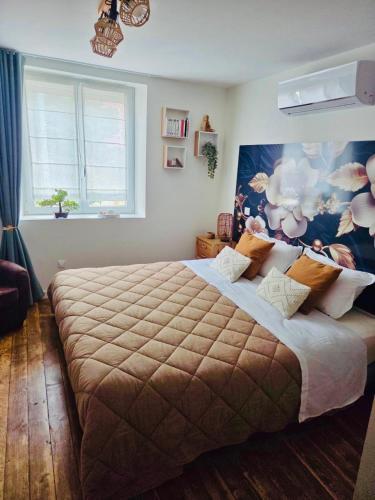 a bedroom with a large bed and a window at LA P'TITE EVASION in Heimsbrunn
