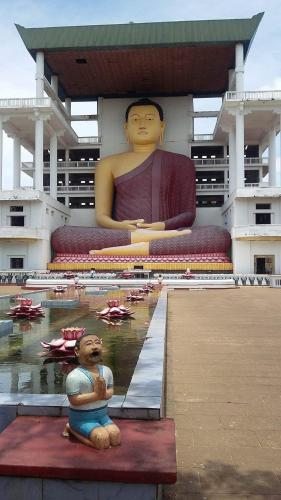 a large statue of a man in a pool in a building at Seasons Four Jungle Treehouse in Matara