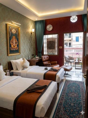 a hotel room with three beds and a chair at NG House in Indore