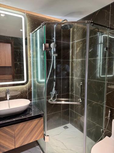 a bathroom with a glass shower and a sink at 7Homestays in Ðông Khê