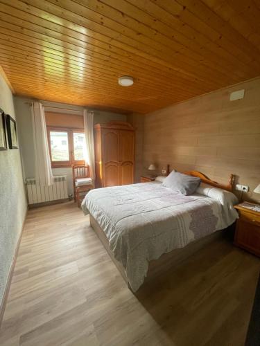 a bedroom with a bed and a wooden ceiling at El Jardí ideal para familias y grupos in Arfa