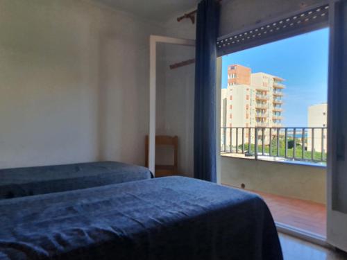 a bedroom with two beds and a window with a view at Payet Apartments in L'Estartit