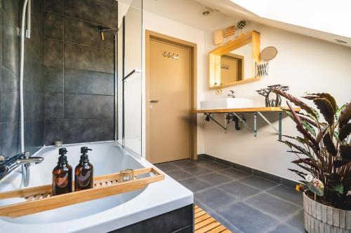 a bathroom with a tub and a sink at Private spa - La Sparenthèse in Ciney