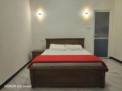 a bedroom with a bed with a red blanket at cassiopeia escape in Kottawa