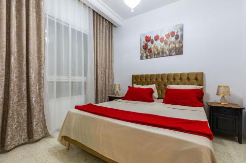 a bedroom with a large bed with red pillows at VIP Home in El Aouina Station