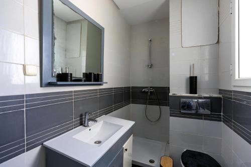 a bathroom with a sink and a mirror at VIP Home in El Aouina Station