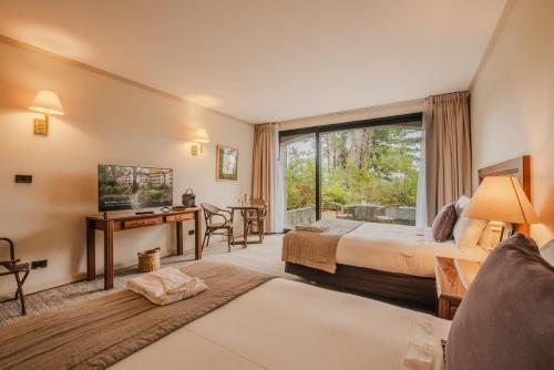 a hotel room with a bed and a window at Hotel Puerta del Sur in Valdivia