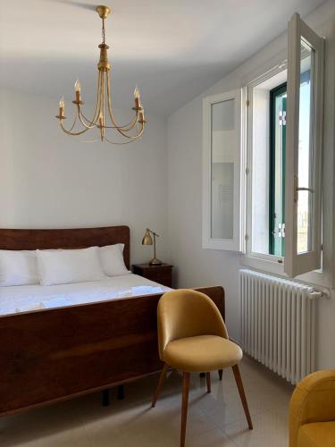 a bedroom with a bed and a chair and a chandelier at Sea Breeze Terrace in Monopoli
