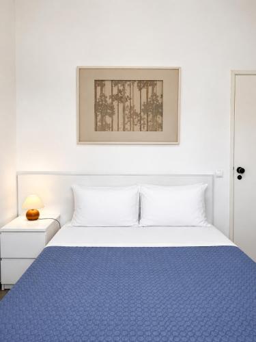 a bedroom with a bed with a blue blanket at Apartamentos Central in Quarteira