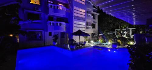 a large building with blue lights in front of it at EBENEZER Apartment in Diani Beach