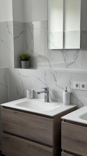 a white bathroom with a sink and a mirror at VE Apartments Colbitz in Kolbitz