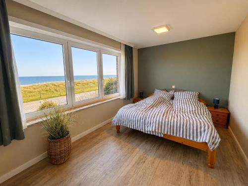 a bedroom with a bed with a view of the ocean at Haus Nige Wark - Ferienwohnungen in Cuxhaven