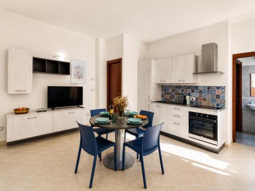 a kitchen and dining room with a table and chairs at Corte Dei Fiori Acquaviva Apartments in Marittima