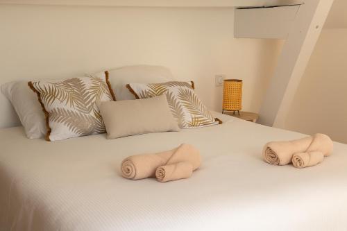 a bed with three towels on it with pillows at Rêves de Canopée in Le Loroux-Bottereau