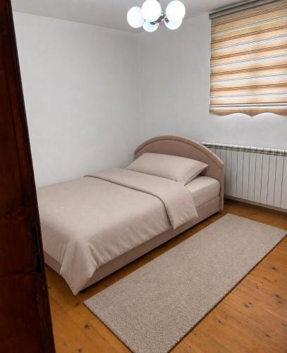a bed in a bedroom with a white wall at Canovic vacation in Plav