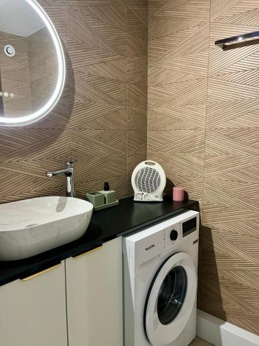 a bathroom with a washing machine and a sink at Cosy Sunnyland, accès direct plage et parking privatif in La Grande Motte
