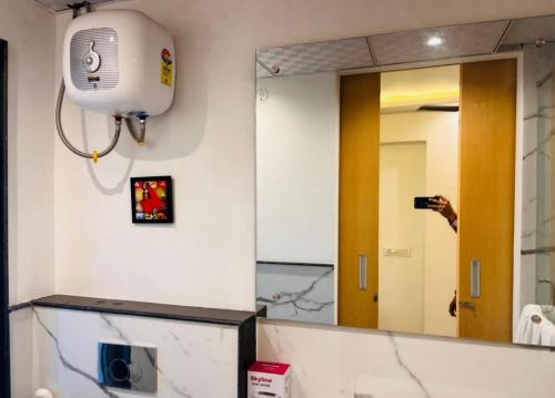 a person taking a picture of a bathroom mirror at Golden Studio With Swimming pool in Jaipur
