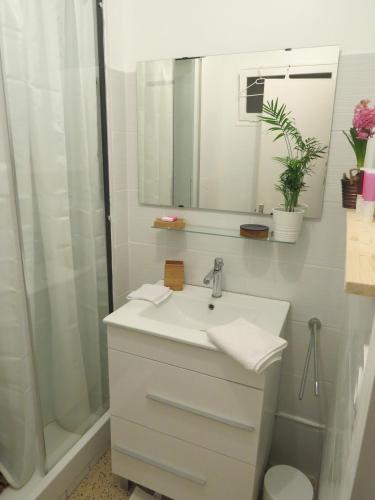 a white bathroom with a sink and a shower at Chambre calme Aux Iris in Grandvelle-et-Perrenot