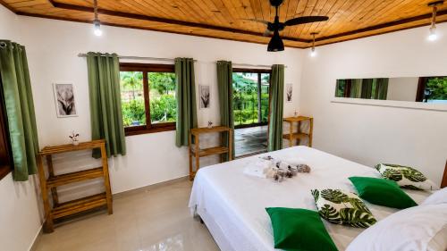 a bedroom with two beds and a wooden ceiling at Refúgio Casinha Branca in Duque de Caxias