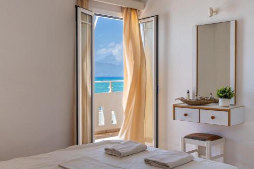 a bedroom with a bed and a large window at Nefeli Rooms with Sea View in Kalamaki in Kalamaki
