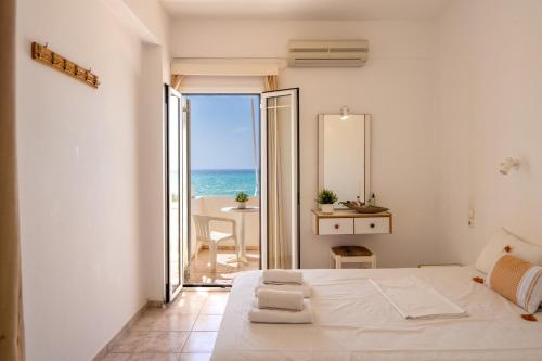 a bedroom with a bed and a view of the ocean at Nefeli Rooms with Sea View in Kalamaki in Kalamaki
