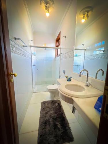 a bathroom with a sink and a toilet and a mirror at Estadia Diamantes in Diamantina