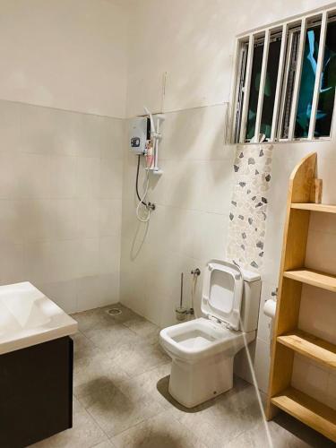a white bathroom with a toilet and a sink at Almasi lounge in Arusha